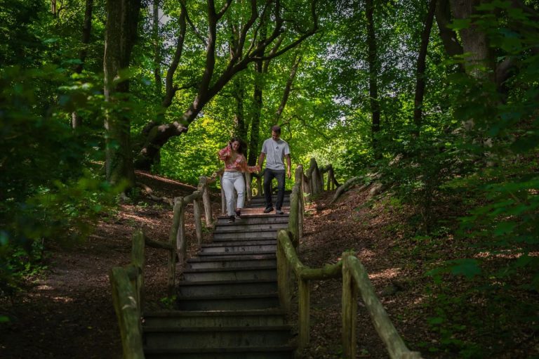 Koppel loopt een houten trap af in een groen bos